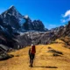 Primer plano de zapatillas de trail sobre una roca en un sendero de montaña al amanecer, imagen que sugiere el uso de la sportiva prodigio pro 2 para largas distancias técnicas.
