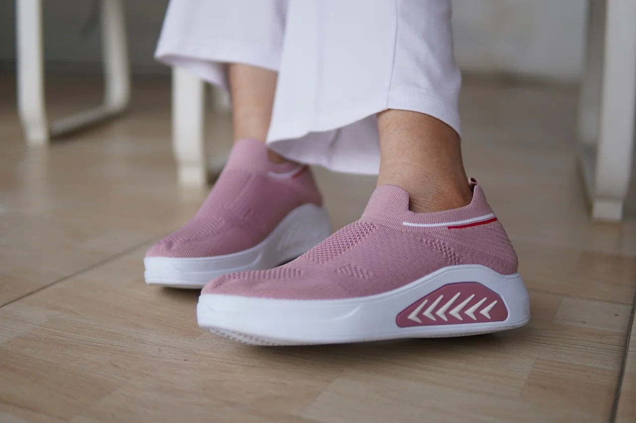 Primer plano de una yeezy boost 350 v2 boost blanca sobre suelo de hormigón, mostrando el tejido y la suela.